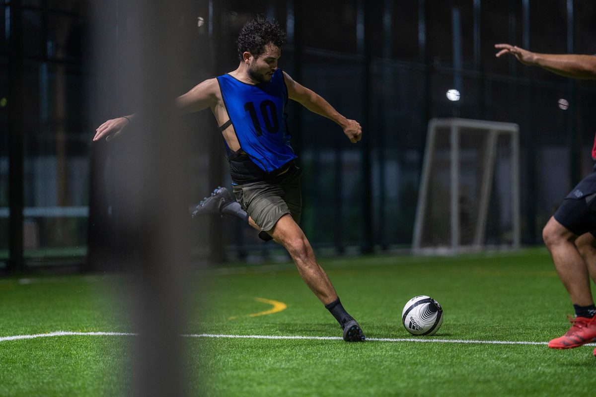 Player striking the ball on the five-a-side pitch